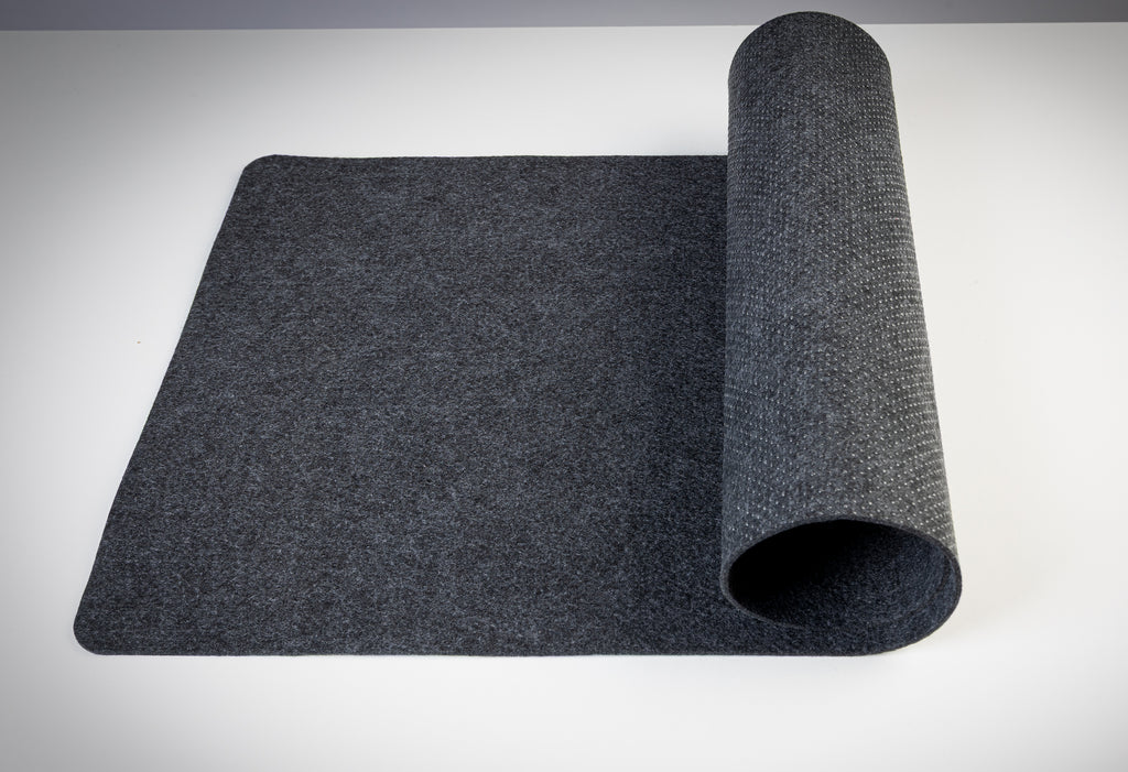 Roll of dark gray desk mat on a white desk