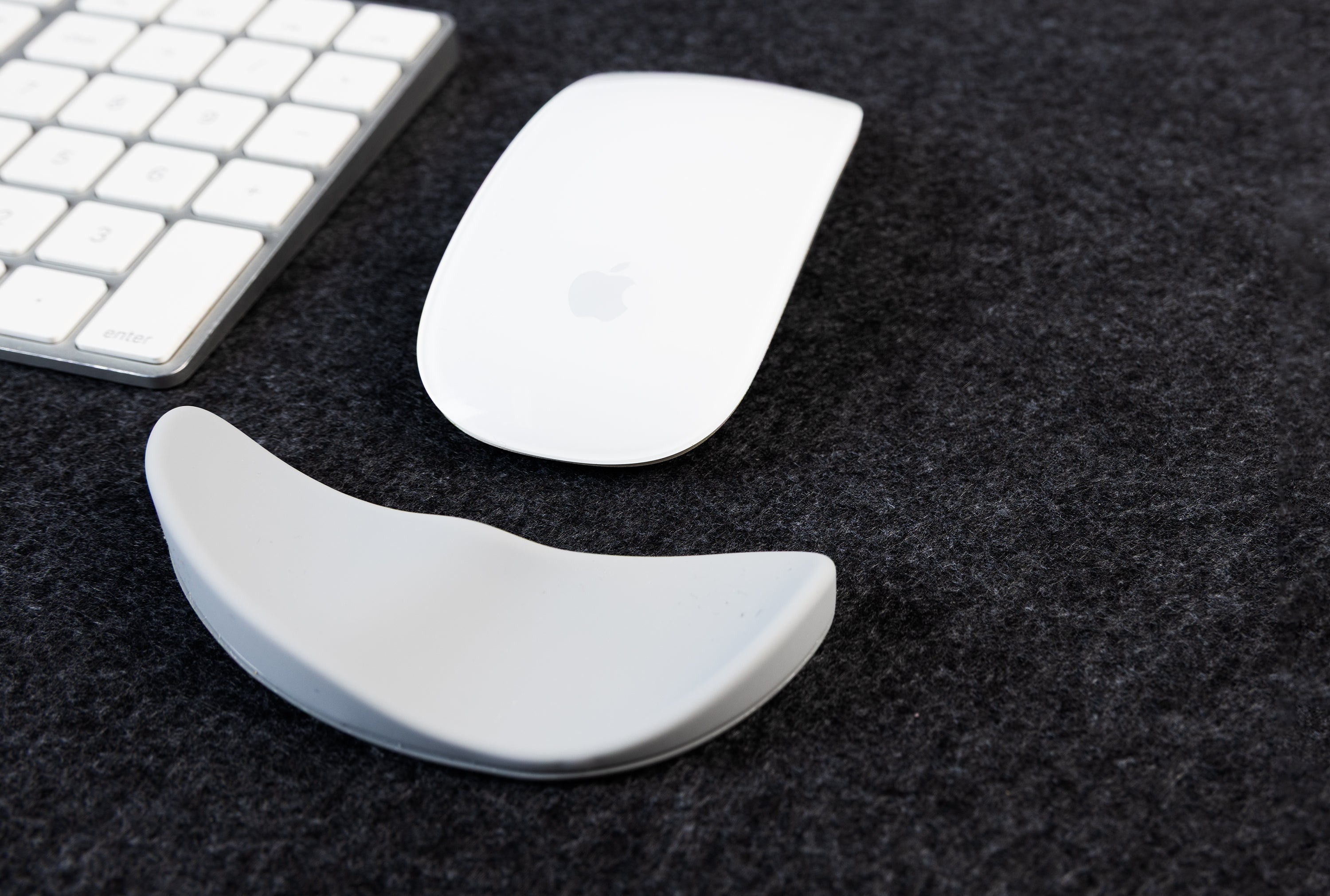 computer mice and wrist support on a felt desk mat